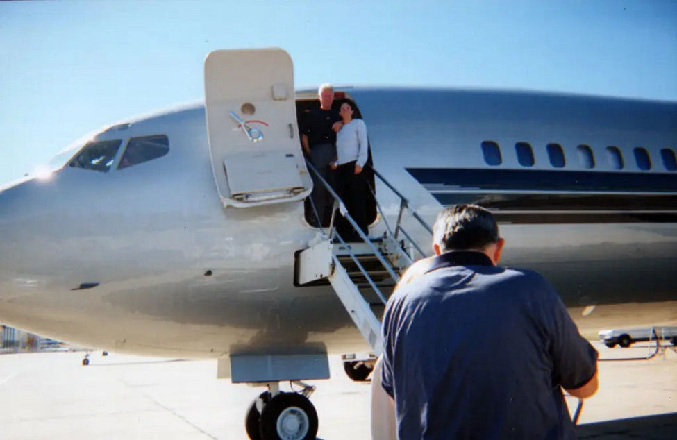 Clinton with Ghislaine Maxwell stand on steps of Eptsein’s private jet, The Lolita Express, in 2002. MEGA