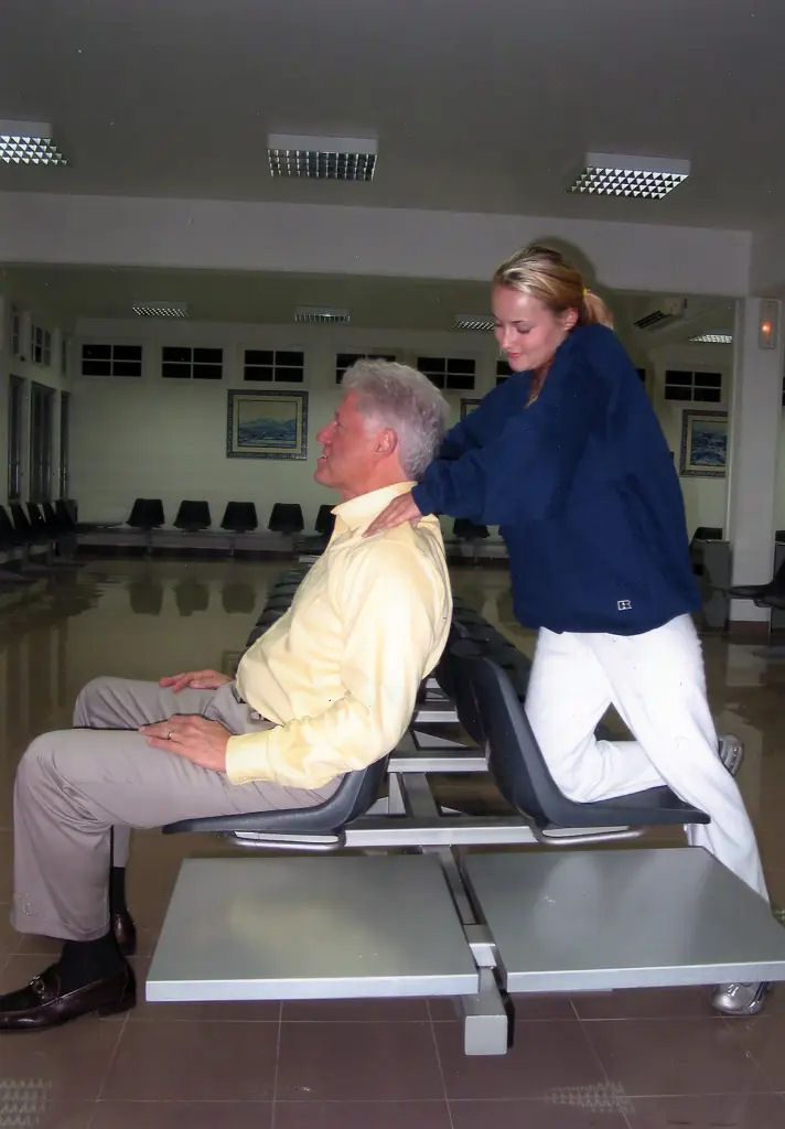 Bill Clinton is given a shoulder massage by Epstein victim, Chauntae Davies, at a small airport in Portugal in 2002 MEGA